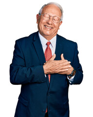 Senior man with grey hair wearing business suit and glasses smiling with hands on chest with closed...