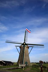 Fotobehang Upside down flag and a windmill © corlaffra