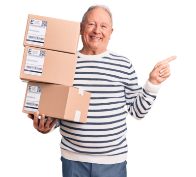 Senior handsome grey-haired man holding delivery boxes smiling happy pointing with hand and finger to the side