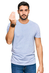 Young hispanic man wearing casual clothes doing italian gesture with hand and fingers confident expression