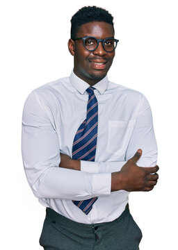 Handsome business black man wearing white shirt and tie happy face smiling with crossed arms looking at the camera. positive person.
