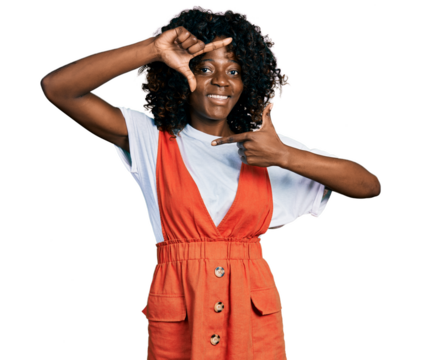 African woman with curly hair wearing casual white t shirt smiling making frame with hands and fingers with happy face. creativity and photography concept.