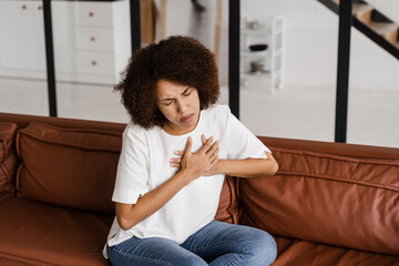 Heart panic attack disease of african american woman. Symptoms of angina pectoris. Attractive sick black girl with heart ilness infarkt.