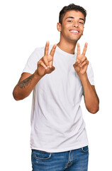 Young handsome african american man wearing casual white tshirt smiling looking to the camera...