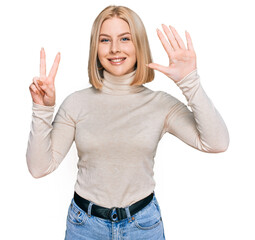 Fototapeta na wymiar Young blonde woman wearing casual clothes showing and pointing up with fingers number seven while smiling confident and happy.