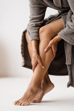 African american girl touching her legs and looking at veins. Deep vein thrombosis and varicose of woman. Sclerotherapy procedure at visiting vascular surgeon doctor.