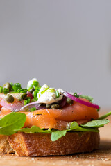 Open sandwich with smoked salmon, pickled onions, sour cream and capers