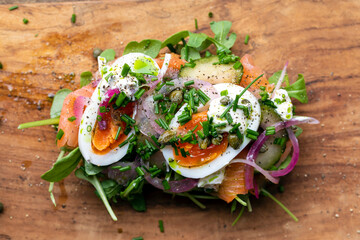 Open sandwich with smoked salmon, egg, pickled onions, sour cream and capers
