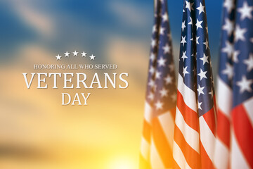 American flags with Text Veterans Day Honoring All Who Served on sunset background. American...