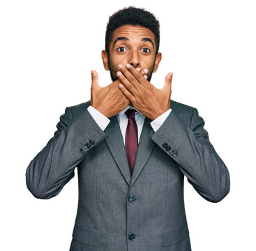 Young african american man wearing business clothes shocked covering mouth with hands for mistake. secret concept.