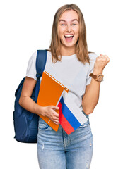 Beautiful young blonde woman exchange student holding russian flag screaming proud, celebrating...