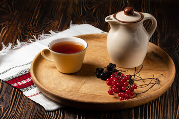 cup of herbal tea and teapot on wooden table
