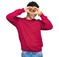 Young handsome man wearing casual clothes doing heart shape with hand and fingers smiling looking through sign