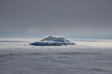 Antisana Volcano in Ecuador. Snow covered volcanic mountain standing above the clouds. 
