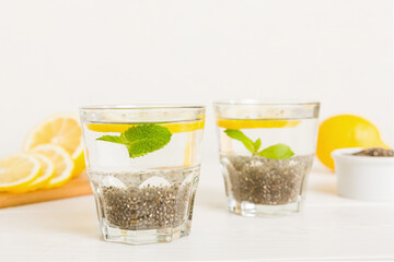 Healthy breakfast or morning with chia seeds lemon and mint on table background, vegetarian food, diet and health concept. Chia pudding with lemon and mint