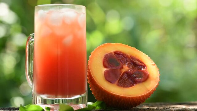 Gac fruits and cold drinks on nature background.