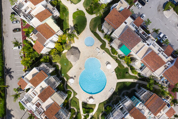Poolside with swimming pool, umbrellas and sunbeds. Nobody. Summer holidays. Aerial view