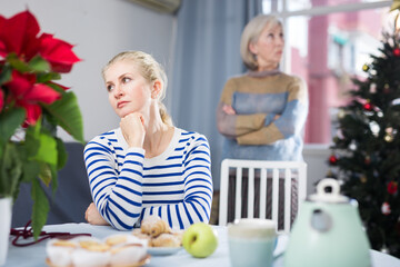 Portrait of an offended adult daughter at her elderly mother, who quarreled with her before...