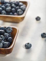 Berries of ripe blueberries in bowls on a white background. Light summer dessert. Vitamins, fiber, antioxidants. Medicine, cooking, cosmetology. There are no people in the photo.