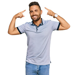 Handsome man with beard wearing casual clothes smiling pointing to head with both hands finger, great idea or thought, good memory