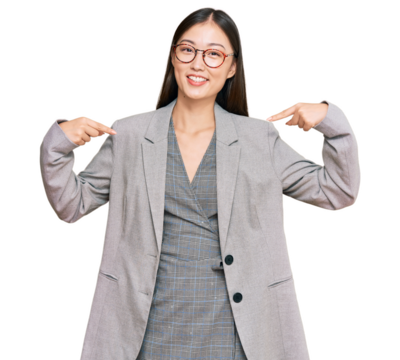 Young chinese woman wearing business clothes looking confident with smile on face, pointing oneself with fingers proud and happy.