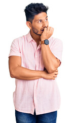 Handsome latin american young man wearing casual summer shirt looking stressed and nervous with hands on mouth biting nails. anxiety problem.