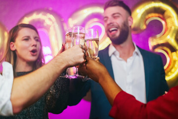 Multiracial people drinking champagne at midnight while on a party in the club