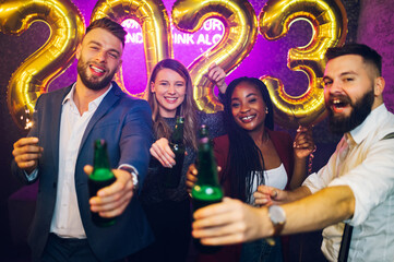 Multiracial people toasting drinks while celebrating new years eve in the club