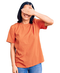 Young beautiful latin woman wearing casual clothes smiling and laughing with hand on face covering eyes for surprise. blind concept.