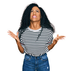 Middle age african american woman wearing casual clothes crazy and mad shouting and yelling with aggressive expression and arms raised. frustration concept.