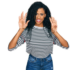 Middle age african american woman wearing casual clothes showing and pointing up with fingers number nine while smiling confident and happy.