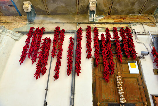 red chillies and onions hanging in the historic center of montalbano jonico basilicata italy