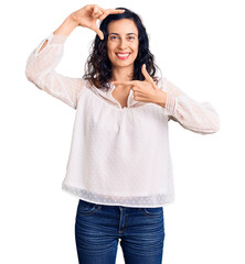 Young beautiful hispanic woman wearing casual clothes smiling making frame with hands and fingers with happy face. creativity and photography concept.