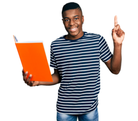 Young african american man holding book surprised with an idea or question pointing finger with happy face, number one