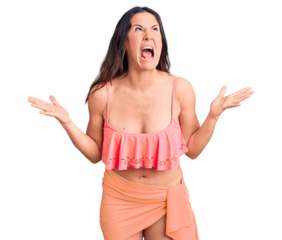 Young beautiful brunette woman wearing bikini crazy and mad shouting and yelling with aggressive expression and arms raised. frustration concept.