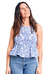 Obraz premium Young beautiful brunette woman wearing casual t-shirt looking away to side with smile on face, natural expression. laughing confident.