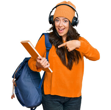 Beautiful brunette young woman wearing student backpack and holding books smiling happy pointing with hand and finger