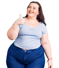 Fototapeta premium Young plus size woman wearing casual clothes doing happy thumbs up gesture with hand. approving expression looking at the camera showing success.