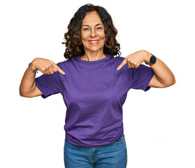 Middle age hispanic woman wearing casual clothes looking confident with smile on face, pointing oneself with fingers proud and happy.