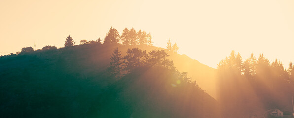 Wide shot of the sunrise over the mountains with light rays casting beautiful lines through the...