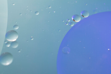 Blue and aqua background of mid-tones and small circles and a large sphere or planet