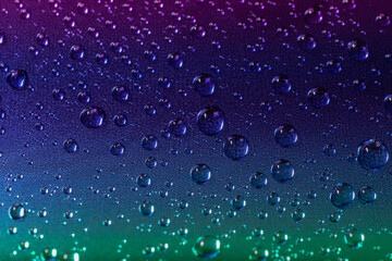 A dark purple background with small spheres or droplets.