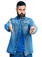Hispanic man with beard with open arms doing hug gesture depressed and worry for distress, crying angry and afraid. sad expression.