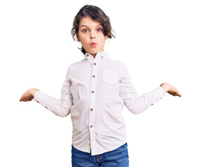 Cute hispanic child wearing casual clothes clueless and confused expression with arms and hands...