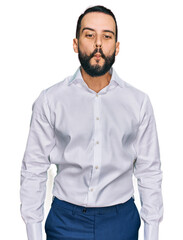 Young man with beard wearing business shirt making fish face with lips, crazy and comical gesture. funny expression.