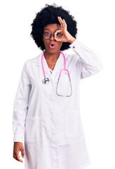 Young african american woman wearing doctor coat and stethoscope doing ok gesture shocked with surprised face, eye looking through fingers. unbelieving expression.