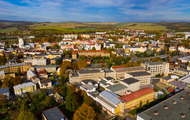 Obraz premium Panoramic aerial view of autumn landscape of Czech town of Krnov with white building of St. Martin church and Town hall on main square on sunny day, Moravian-Silesian Region..