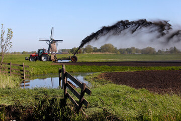 Spreading a mixture of water and fertilized particles onto farmland