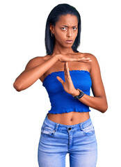 Young african american woman wearing casual summer clothes doing time out gesture with hands, frustrated and serious face