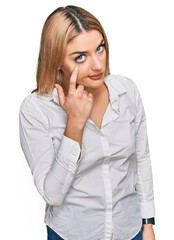 Young caucasian woman wearing casual clothes pointing to the eye watching you gesture, suspicious expression